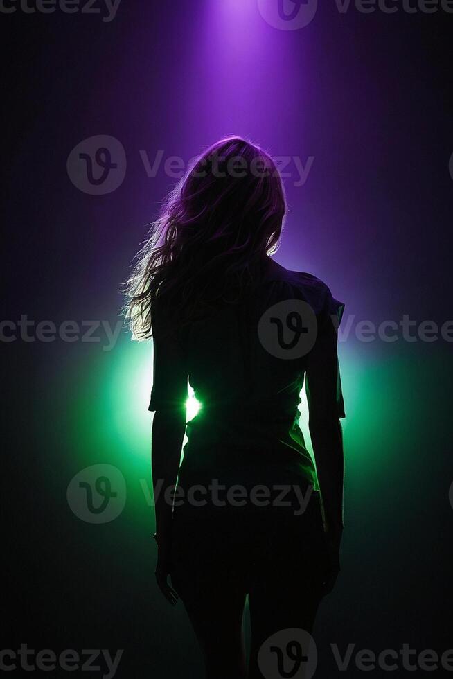 een vrouw staand in voorkant van een spotlight met groen en Purper lichten foto