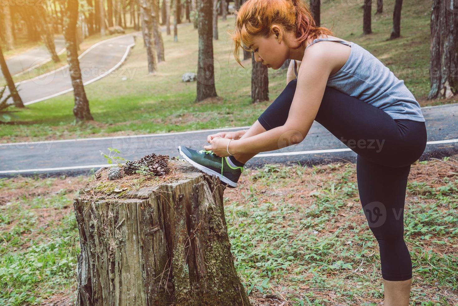 vrouwen oefenen op straat. natuurpark. meisje dat benen opheft om te oefenen. oefening, hardlopen. foto