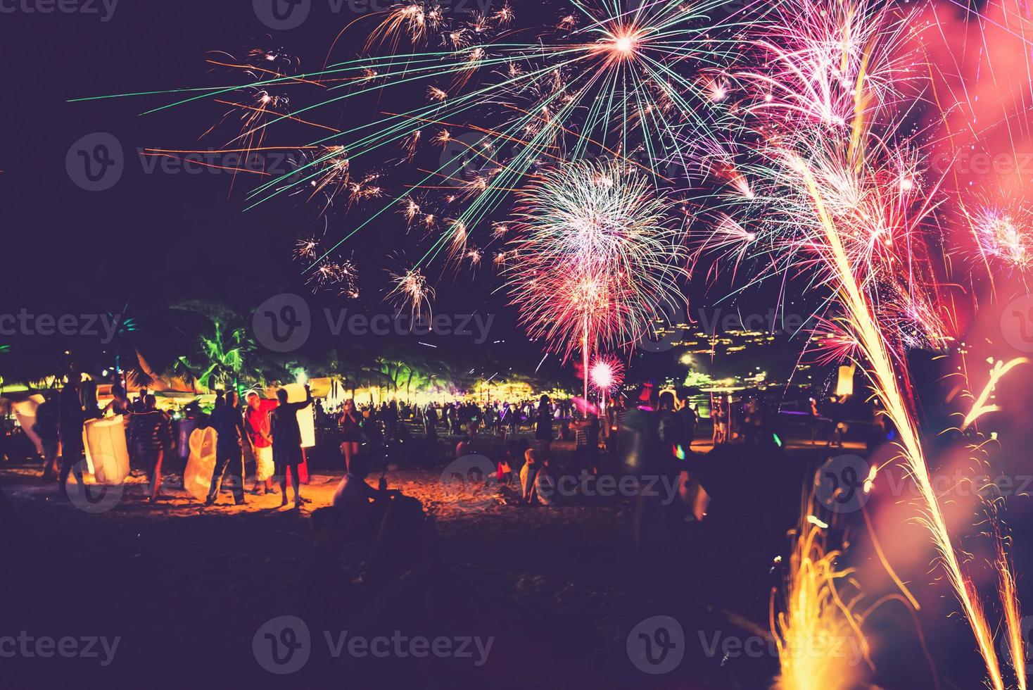 achtergrond feestelijk nieuwjaar met vuurwerk en bokeh. nieuwjaarsvuurwerk op het strand. foto