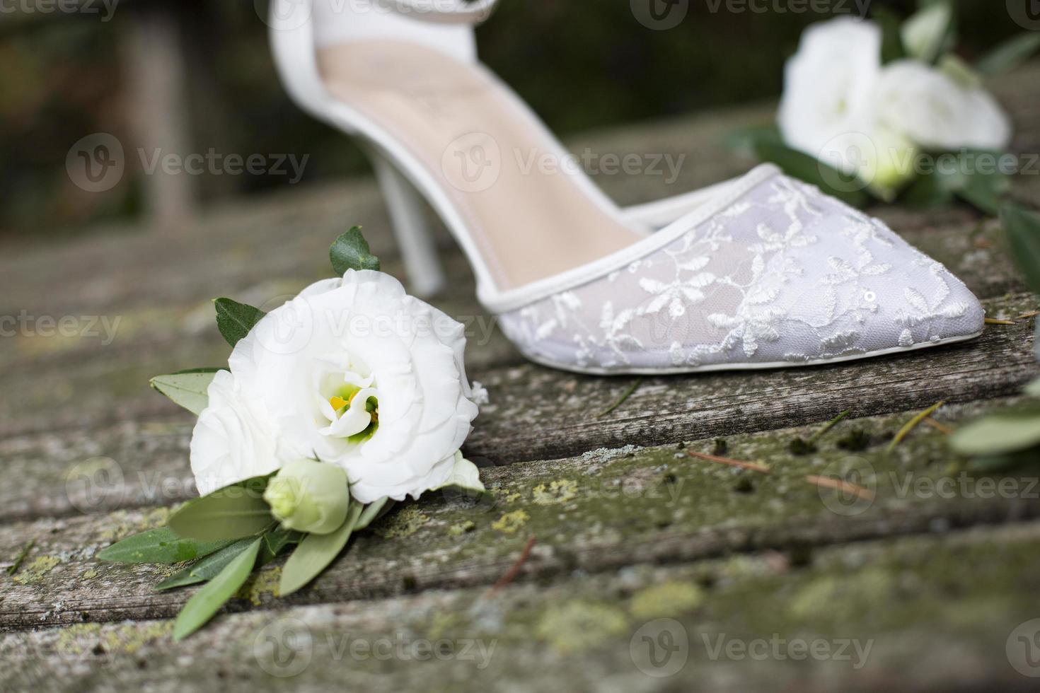 witte trouwschoen met witte bloemen op oude houten planken foto