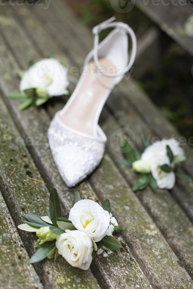 witte trouwschoen met witte bloemen op oude houten planken foto