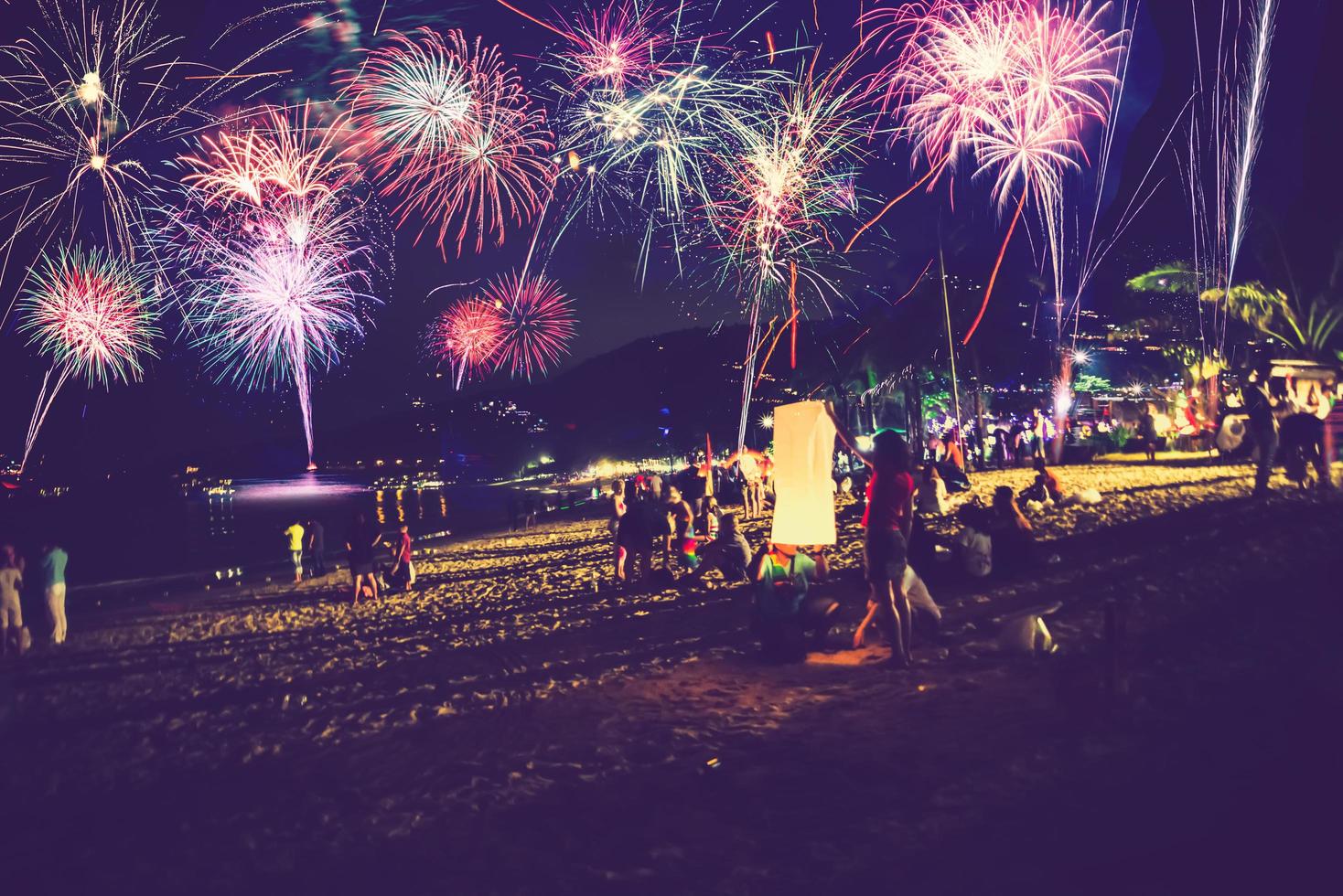 achtergrond feestelijk nieuwjaar met vuurwerk en bokeh. nieuwjaarsvuurwerk op het strand. foto
