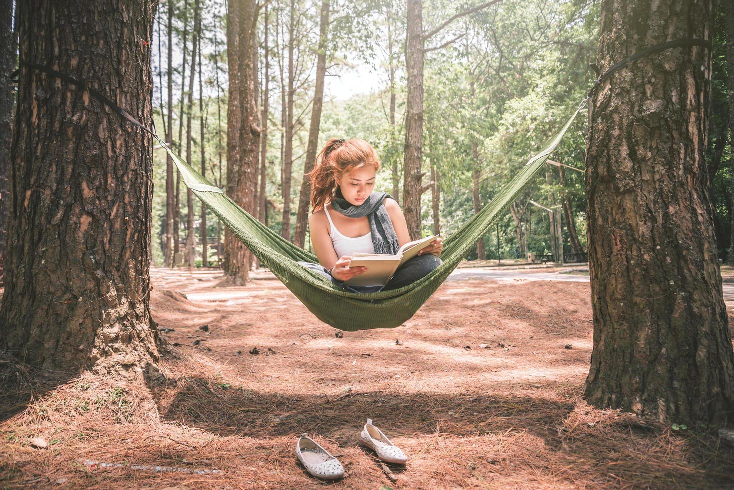 vrouwen zitten lezen. in de hangmat. in de natuurlijke sfeer in het park foto