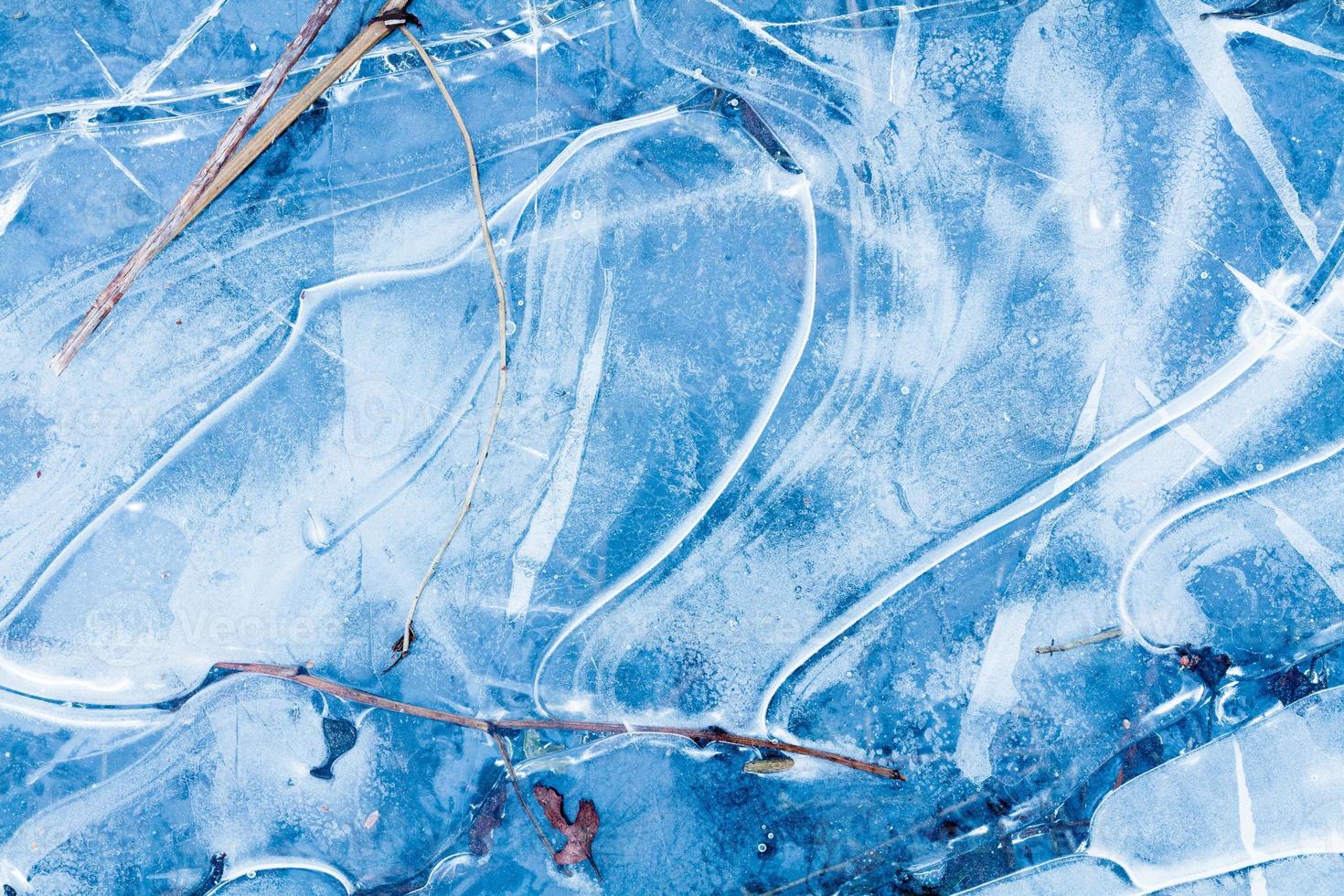 blauwe bevroren watertextuur met patroon op de rivier in het winterbos buitenshuis foto
