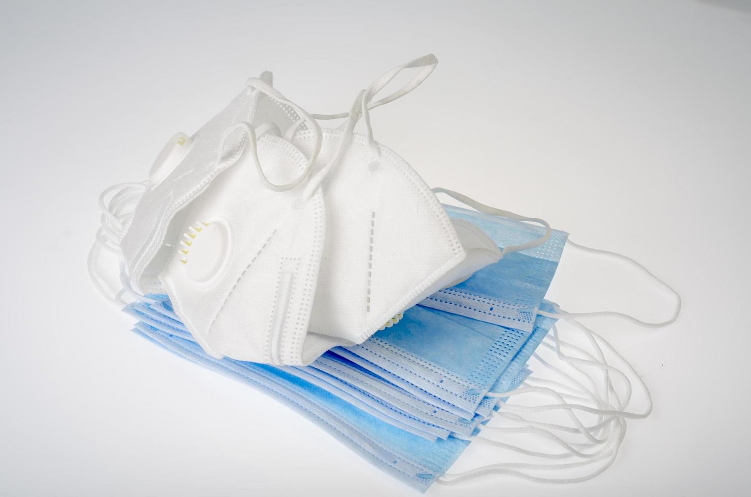 blauwe medische wegwerpmaskers en witte ademhalingstoestellen - bescherming tegen coronavirus foto