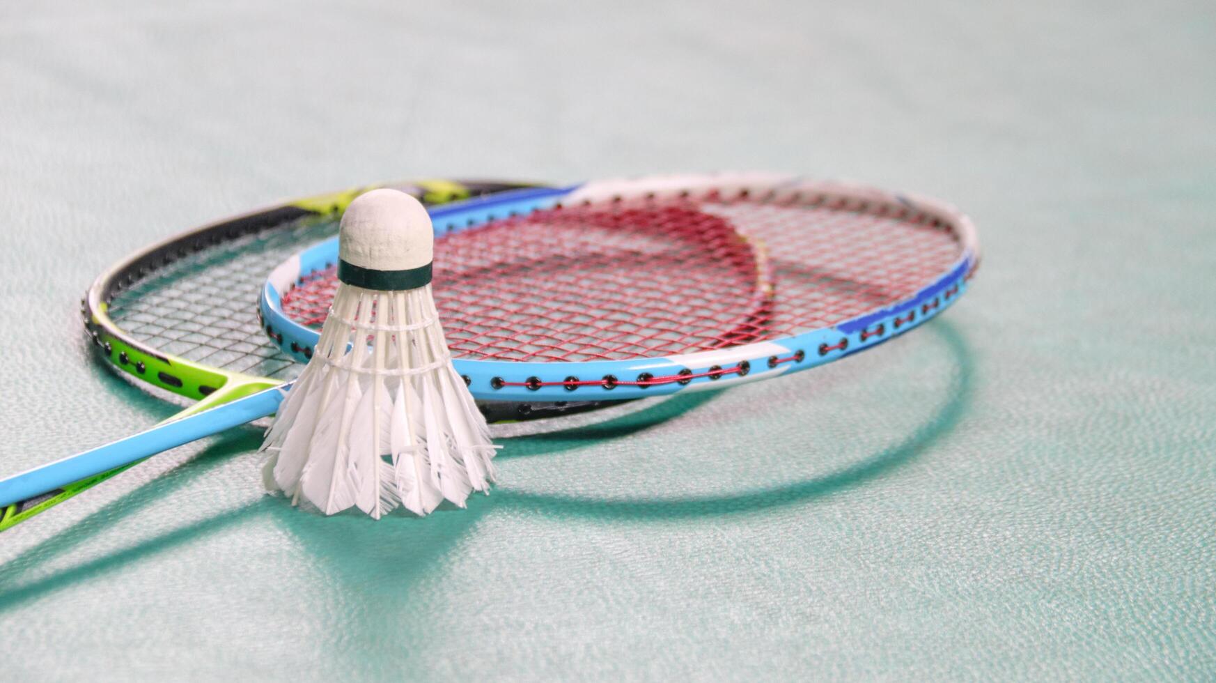 wit badminton shuttles en badminton rackets Aan groen verdieping binnen- badminton rechtbank zacht en selectief focus Aan shuttles en de rackets foto