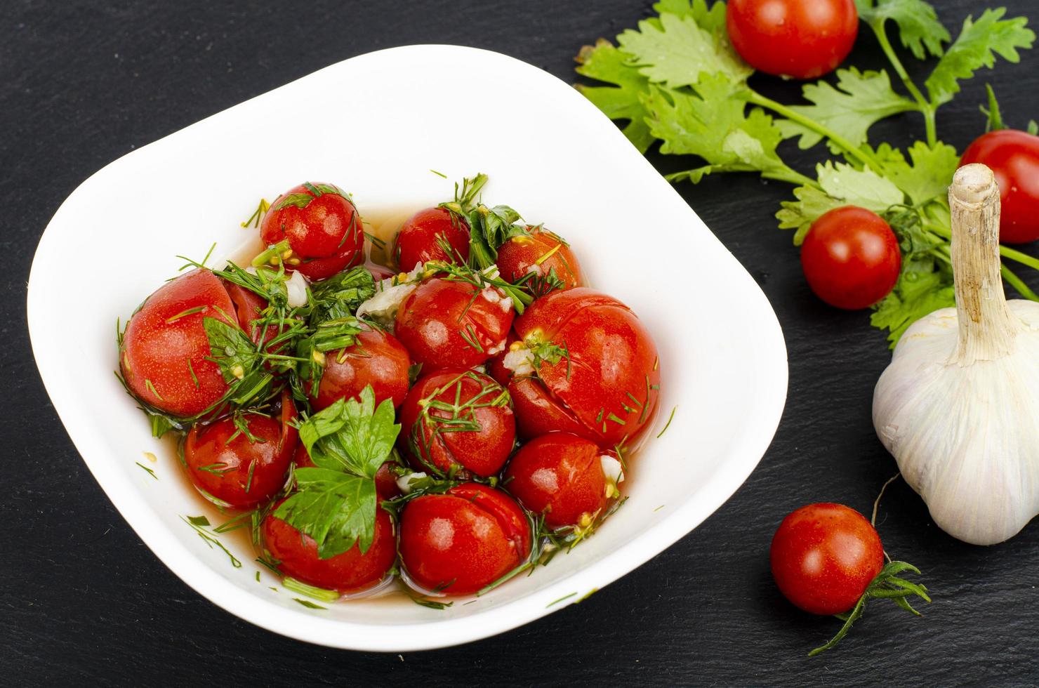 ingelegde tomaten met kruiden en knoflook. studiofoto. foto