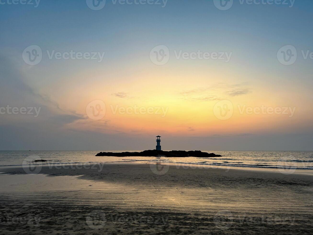een rustig zeegezicht met een vuurtoren silhouet tegen een levendig zonsondergang, perfect voor thema's van reizen en natuur foto