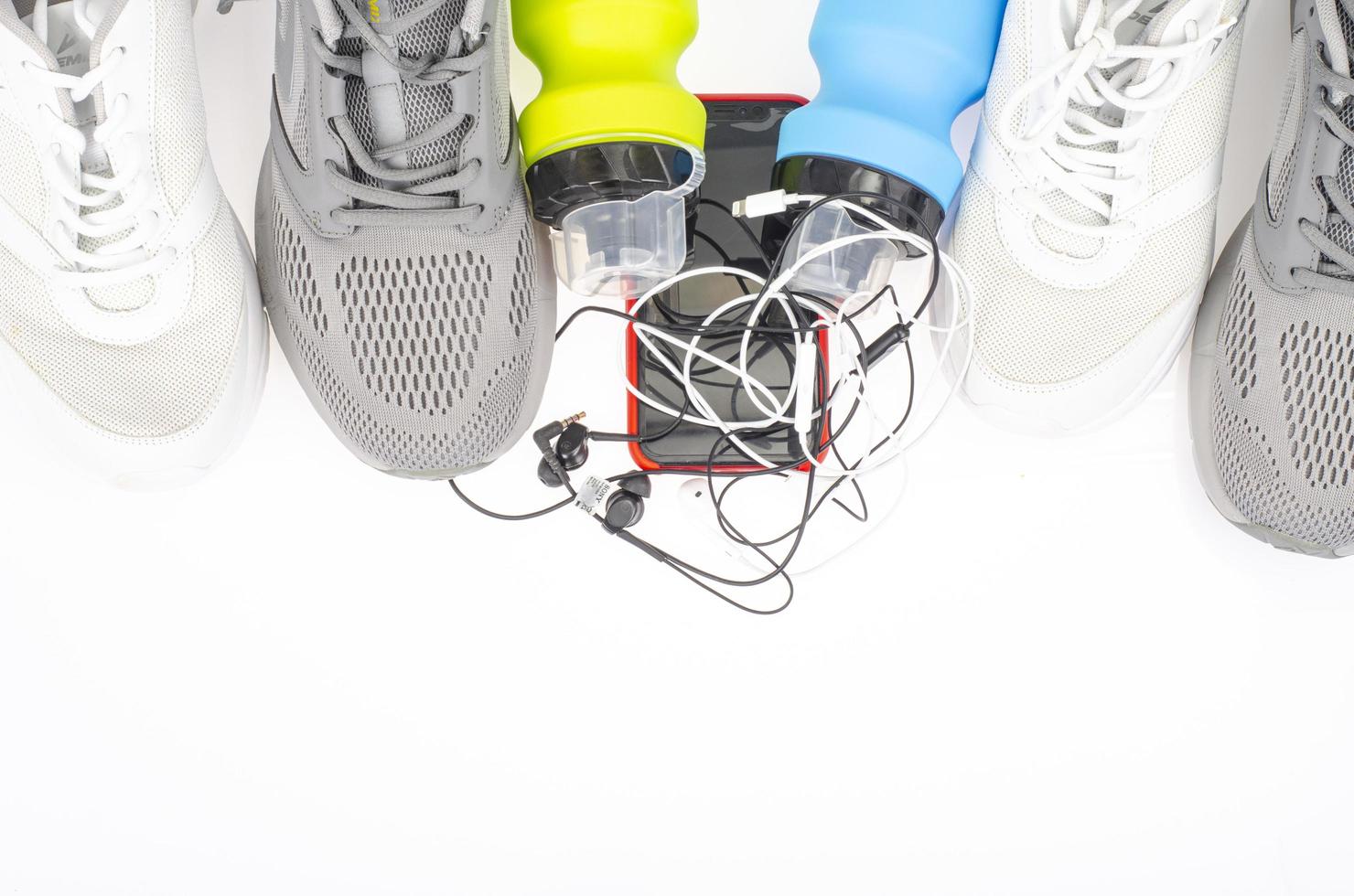 atletiekbaan met sneakers en fles water op zwarte achtergrond. oefeningshulpmiddelen voor gezondheid. studio foto