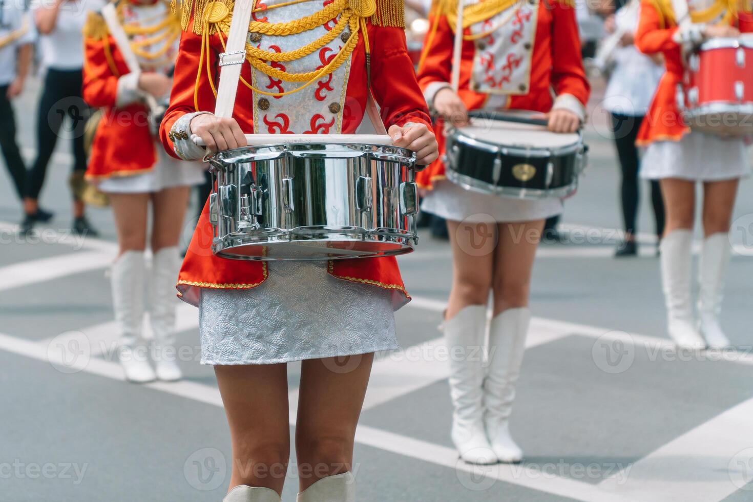 straat prestatie van feestelijk maart van drummers meisjes in rood kostuums Aan stad straat. jong meisjes trommelaar in rood wijnoogst uniform Bij de optocht foto