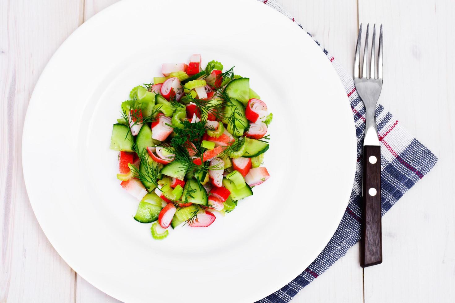 salade van bleekselderij, krabstick, komkommer, groene olijven en dille foto