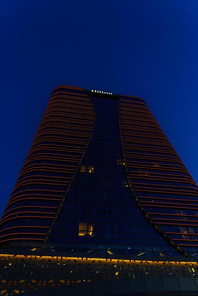 Oezbekistan, Tasjkent - september 27, 2023 hilton hotel gebouw in nacht verlichting Aan een lucht achtergrond. foto