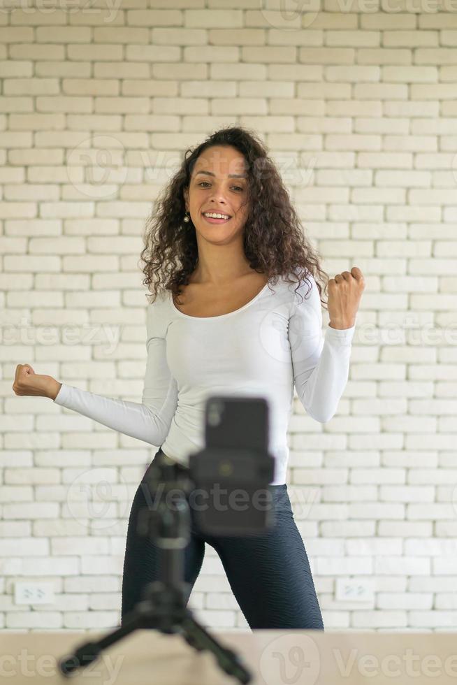 latijnse vrouw heeft haar dansvideo gemaakt met een smartphonecamera. om video te delen met een toepassing voor sociale media. foto
