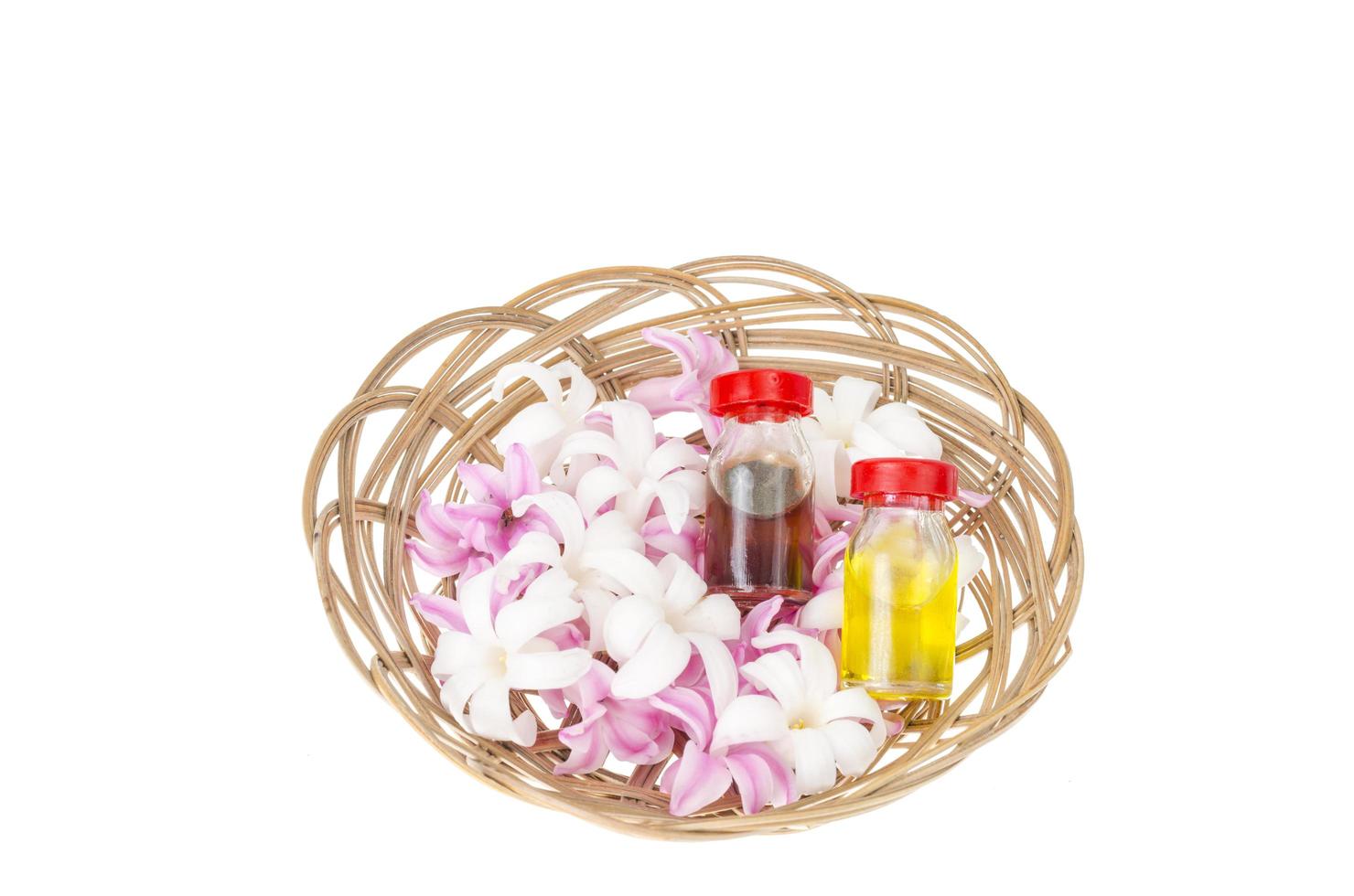 flessen met bloemenolie, hyacintbloemen op witte achtergrond foto