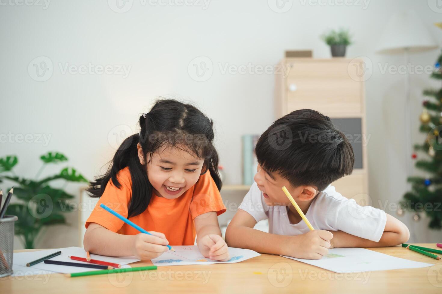 twee kinderen zijn zittend Bij een tafel, tekening en lachend. concept van vreugde en creativiteit, net zo de kinderen zijn verloofd in een pret werkzaamheid samen foto