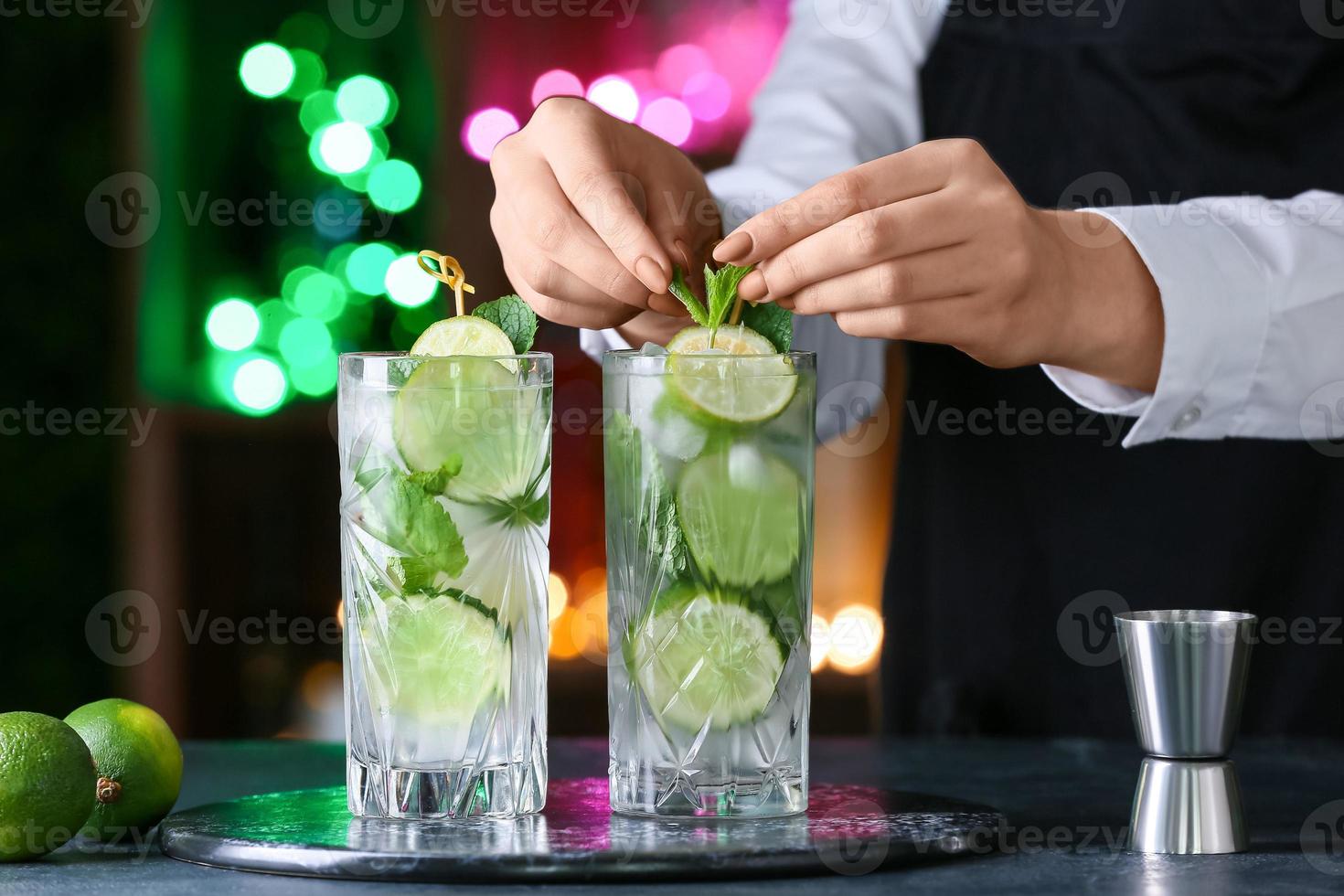 vrouwelijke barman die verse mojito maakt op tafel in bar foto