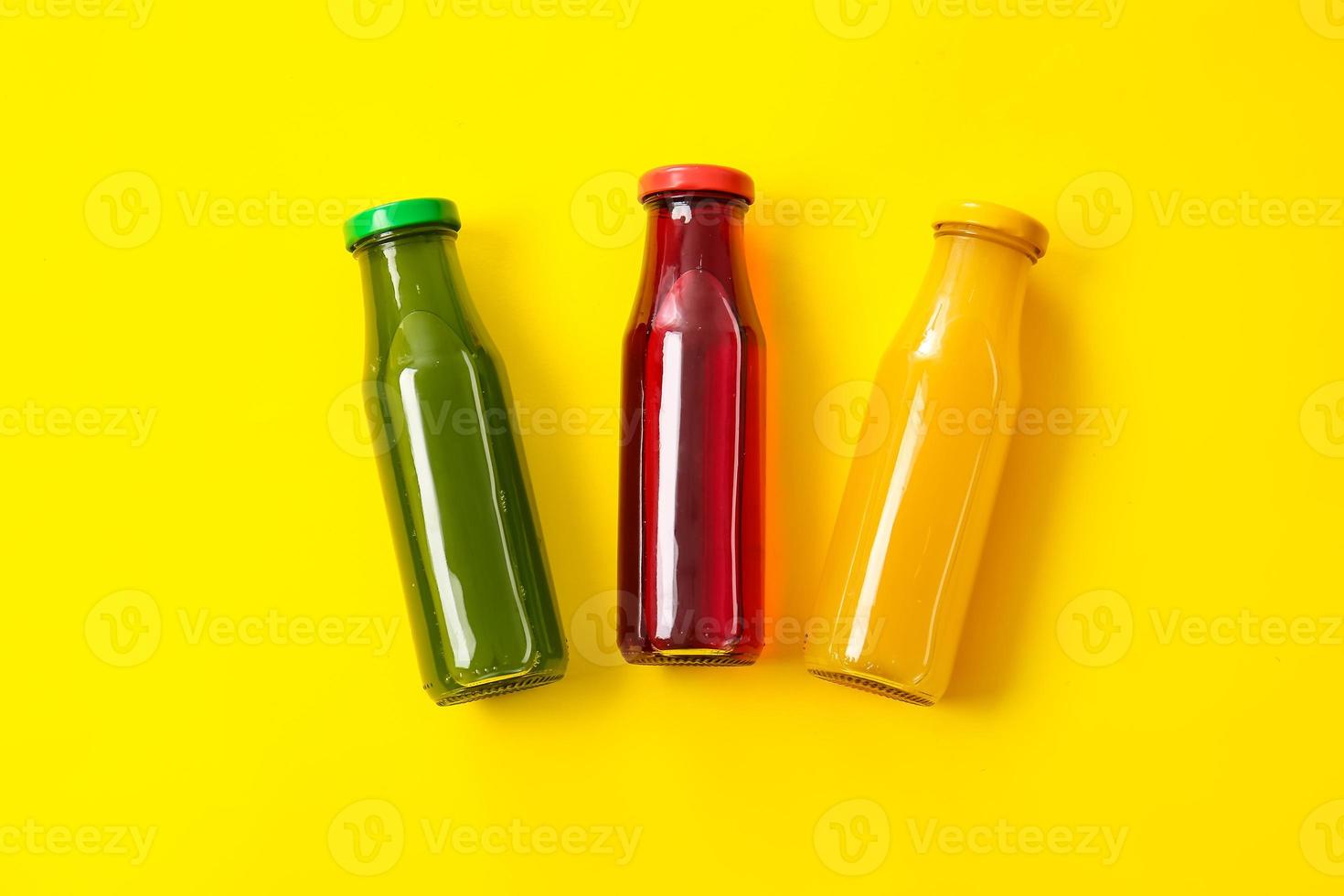 flessen met gezond sap op gekleurde achtergrond foto