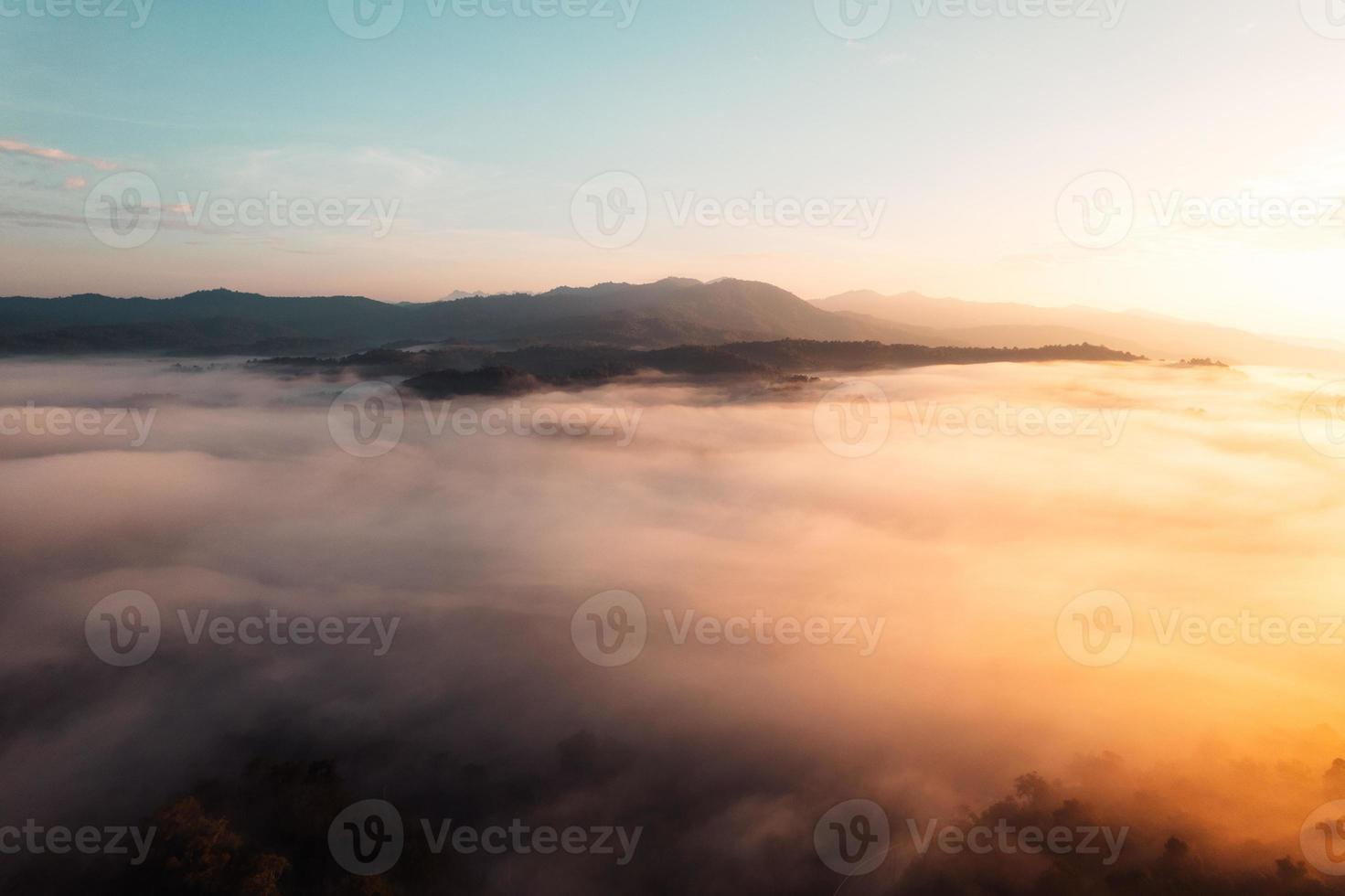 vliegen boven de wolken zonsopgang en mist foto