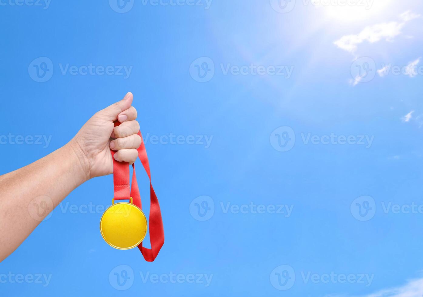 Holding een goud medaille, winnaar, lucht achtergrond foto