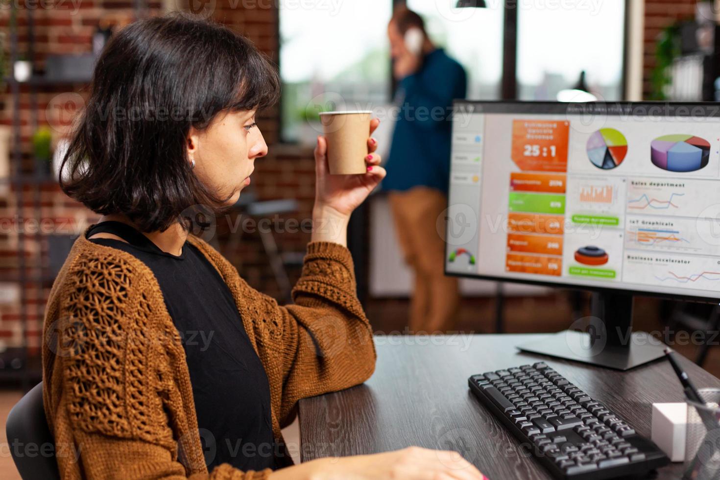 zakenvrouw die naar het computerscherm kijkt en managementgrafieken analyseert foto