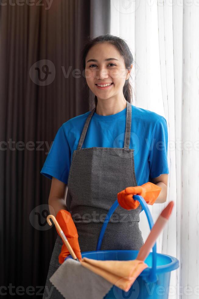 schoonmaak Product, en mand met vrouw Aziatisch personeel schoonmaak onderhoud in slaapkamer naar schoon bacterie Bij appartement. schoonmaakster of hulp in de huishouding met houder naar werk in kamer foto