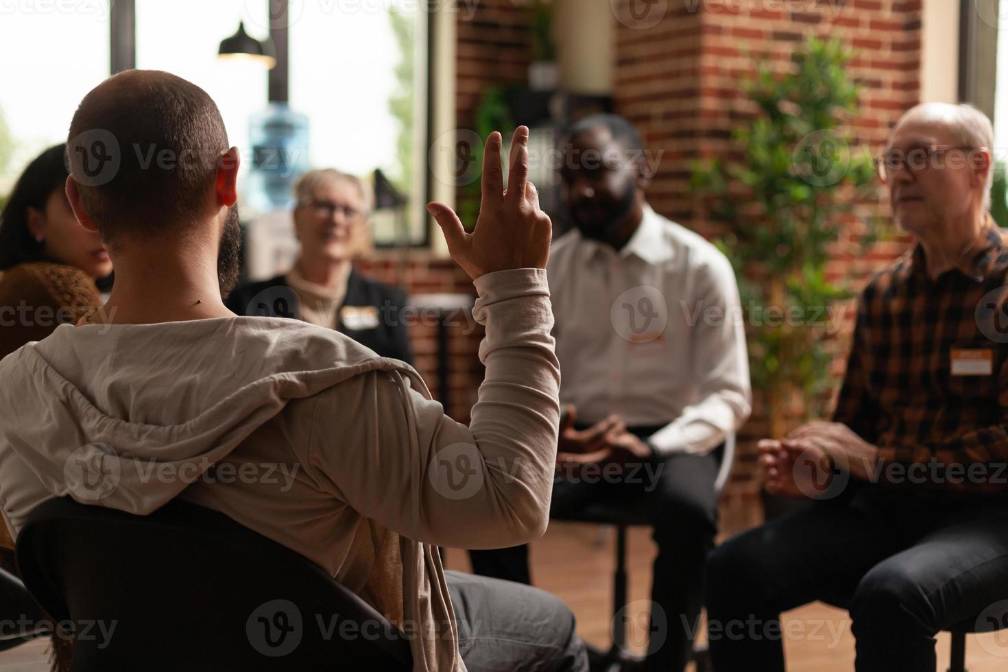 man met verslaving die gezondheidsproblemen deelt met groep tijdens een vergadering foto