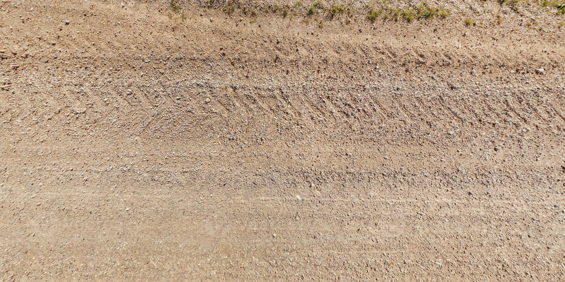 visie van bovenstaand Aan structuur van nat modderig weg met trekker band sporen in platteland foto
