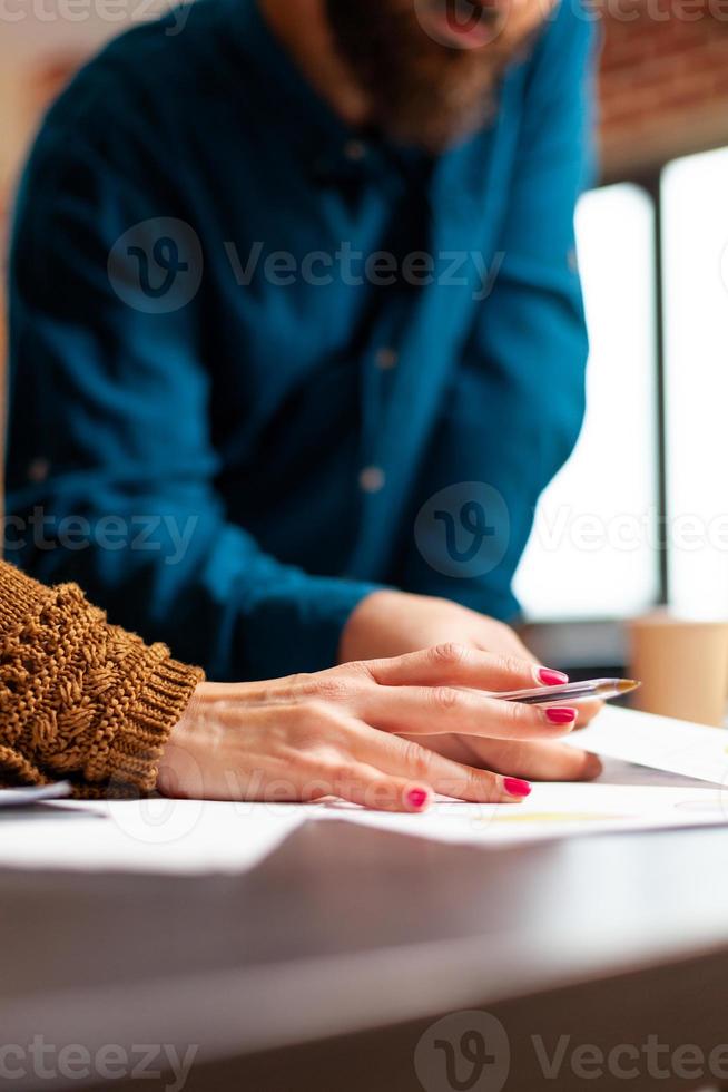 close-up van zakenmensenhanden die marketingpapieren analyseren die bij bedrijfspresentatie werken foto