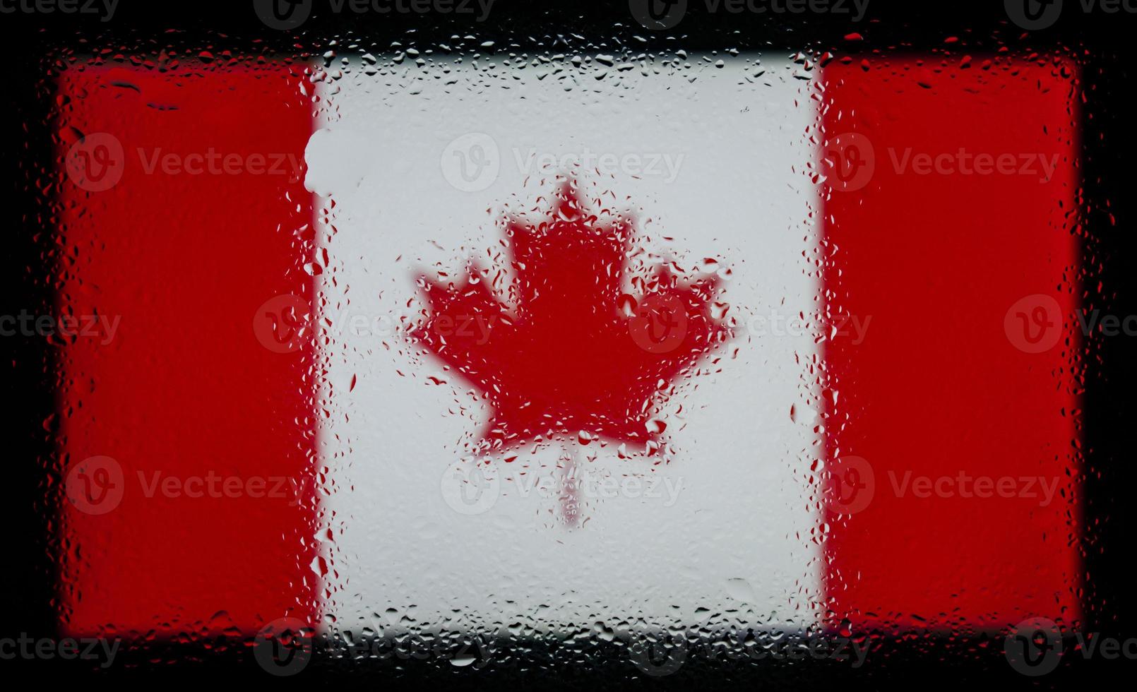 druppels water op de achtergrond van de vlag van Canada. ondiepe scherptediepte. selectieve aandacht. afgezwakt. foto