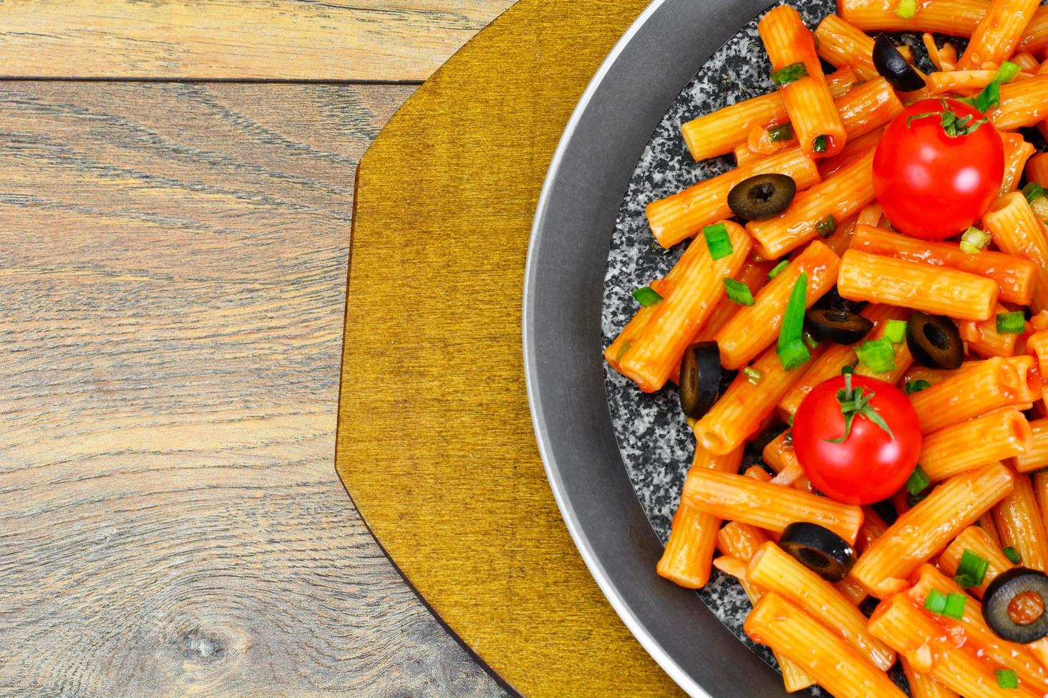 pasta met tomatenketchupsaus, groene uien en kaas foto