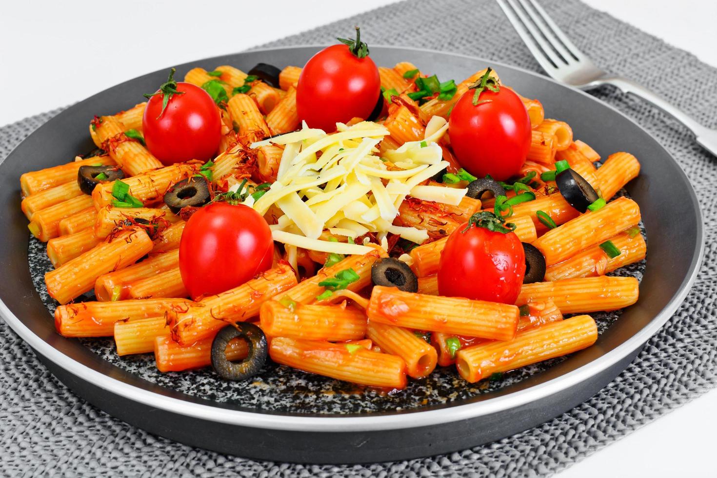 pasta met tomatenketchupsaus, groene uien en kaas foto