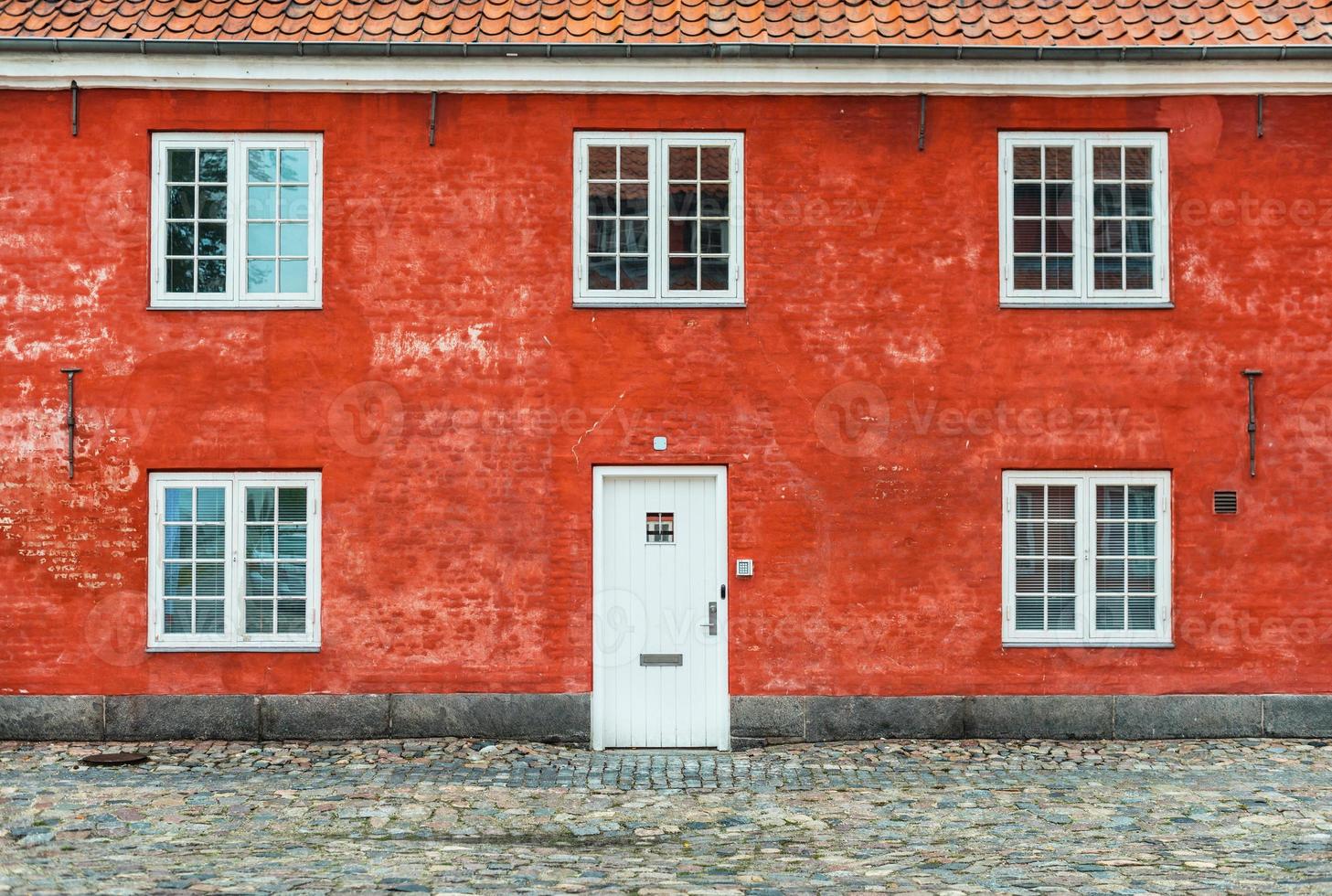 oud rood huis met witte ramen en deur, kastellet, kopenhagen, denemarken foto