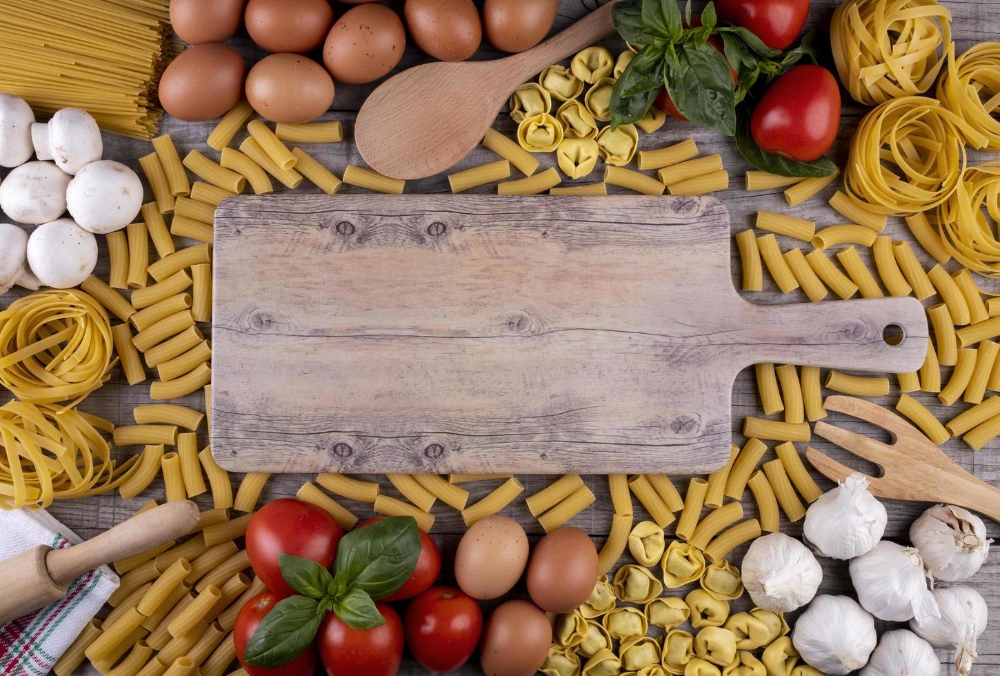 pasta, groenten, eieren, op een houten bord, ingrediënten voor Italiaans restaurant foto