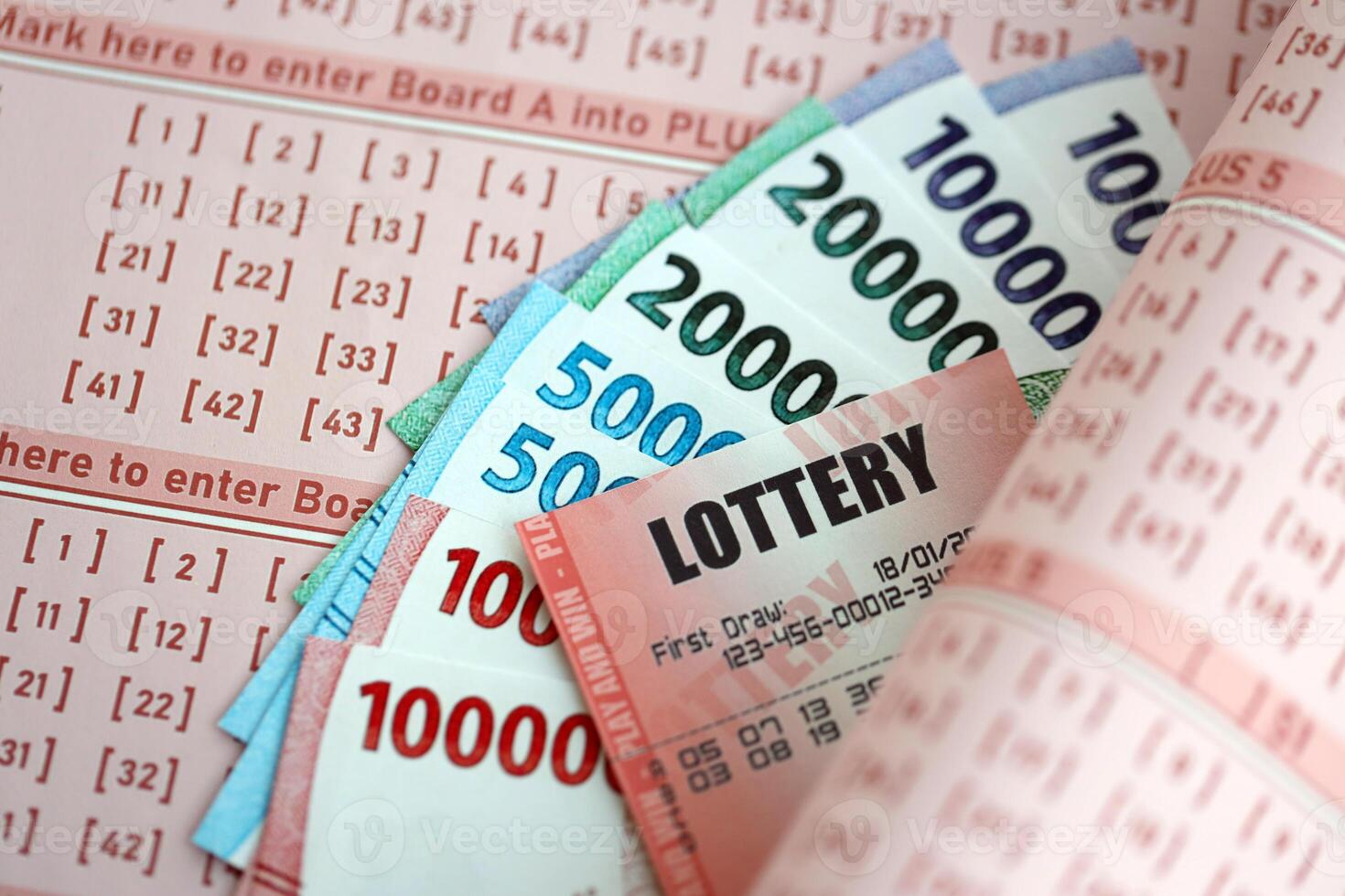 rood loterij ticket leugens Aan roze het gokken lakens met Indonesisch roepia geld rekeningen foto
