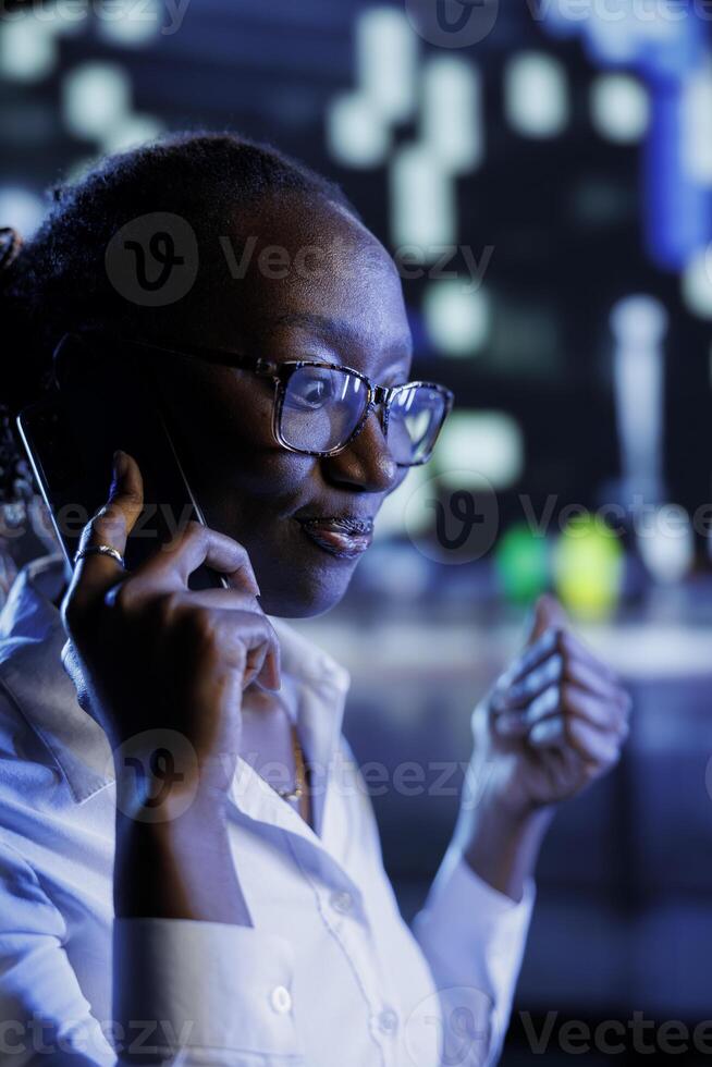 Afrikaanse Amerikaans vrouw wandelen in de omgeving van stadsgezicht Bij nacht, genieten van gesprek over- de telefoon met het beste vriend. inwoner wandelen huis van werk, maken telefoon oproepen naar maken pendelen meer plezierig foto