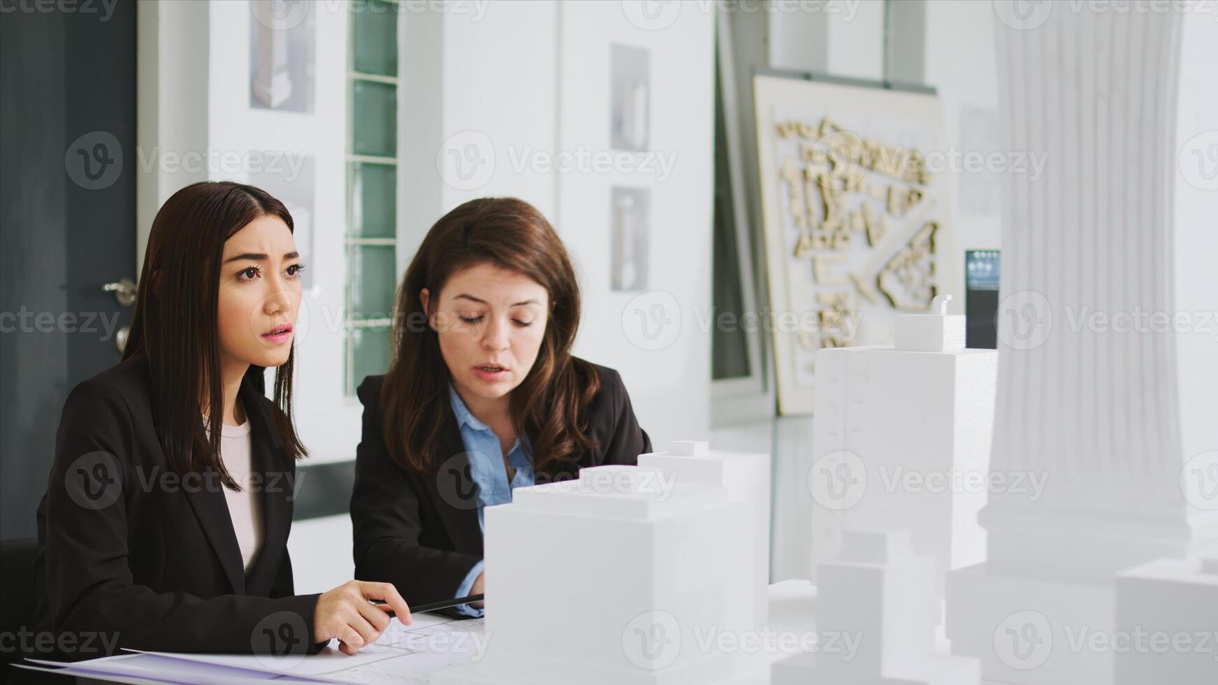 bouwkundig agentschap arbeiders nemen aantekeningen Aan blauwdrukken, berekenen echt schaal metingen naar ervoor zorgen de perfect elementen voor de bouw team. Dames ontwikkelaars aan het studeren 3d gedrukt model. foto