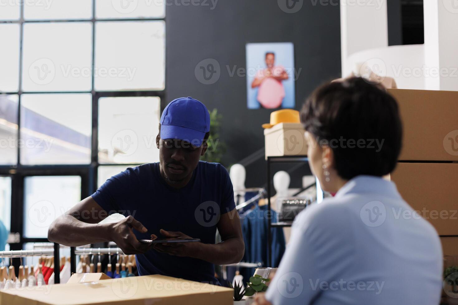 Afrikaanse Amerikaans koerier nemen foto van dozen, bespreken klant Verzending details met werknemer in kleding op te slaan. arbeider voorbereidingen treffen pakketjes voor levering, werken met online bestellingen in winkel