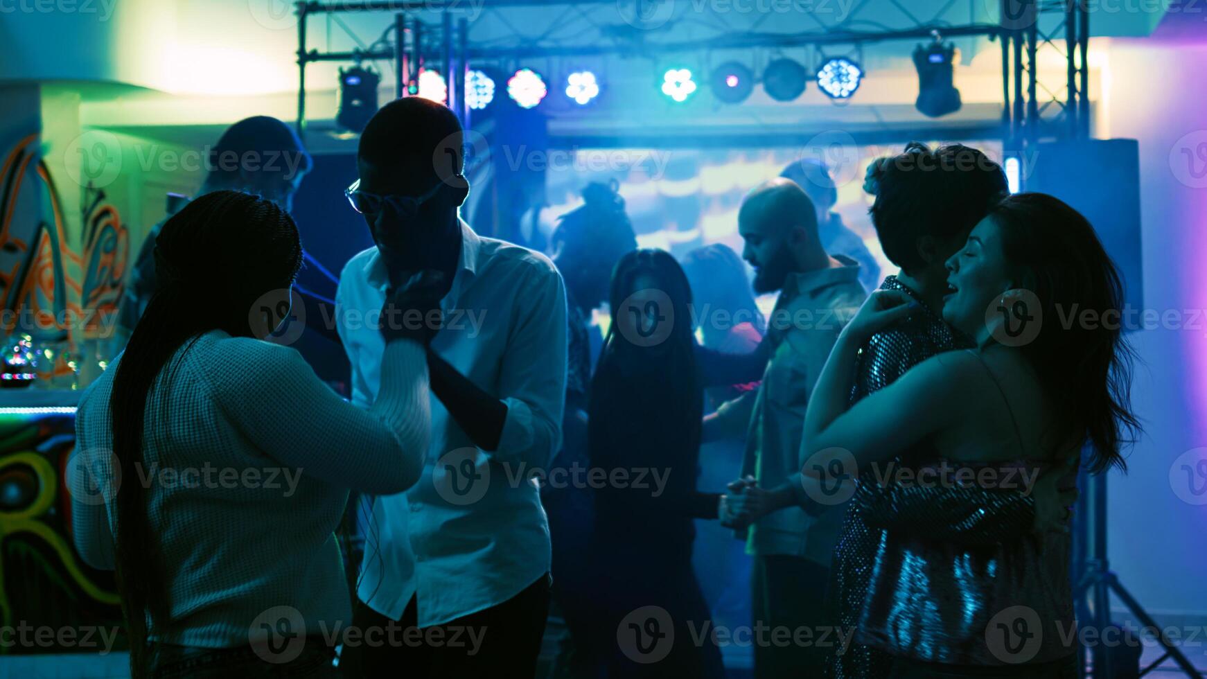 romantisch mensen dansen in paren Aan dans vloer, feesten met langzaam muziek- Bij discotheek. vrolijk paren genieten van dans partij met stadium lichten en drankjes, vermaak evenement. handheld schot. foto