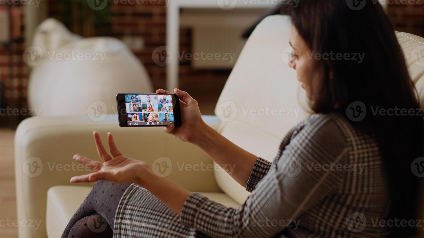 beheer uitvoerend gebruik makend van smartphone naar delegeren project taken naar medewerkers gedurende videoconferentie ontmoeting. manager Bij huis Holding internet video-oproep Aan telefoon met verschillend team foto