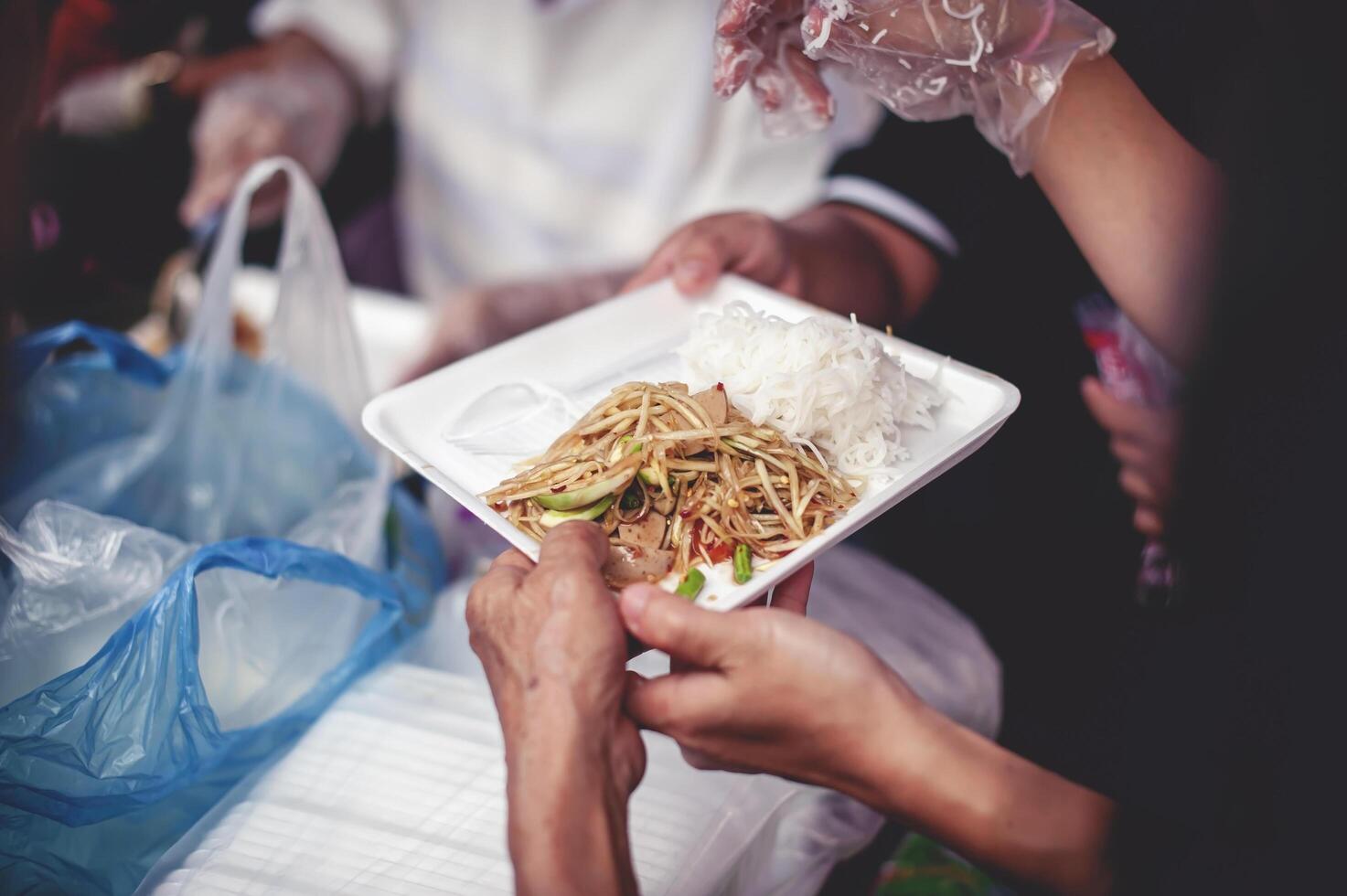 van hand- naar hand. sharing voedsel met dakloos foto