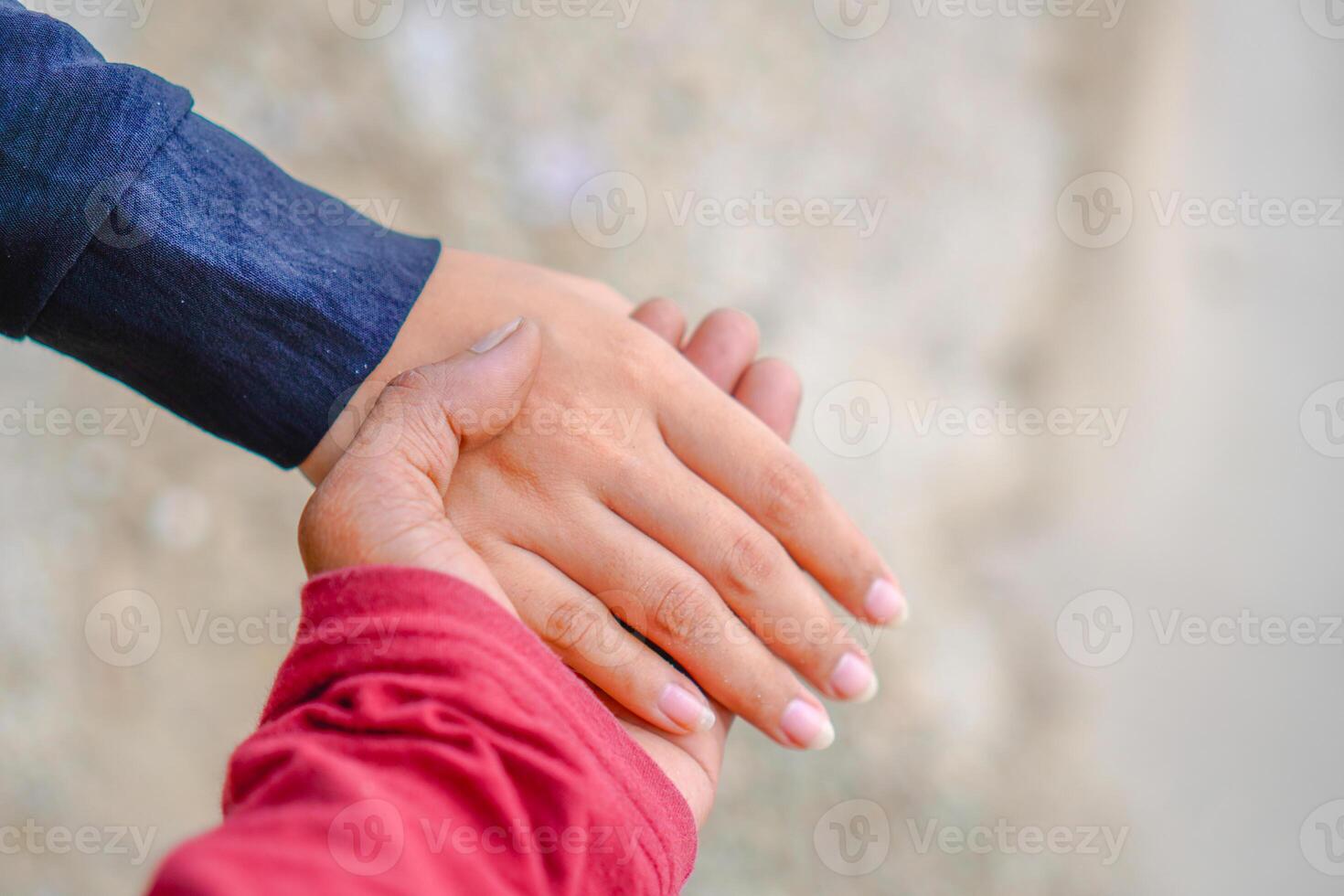 de handen van een paar Holding handen tegen de achtergrond van strand zand. foto