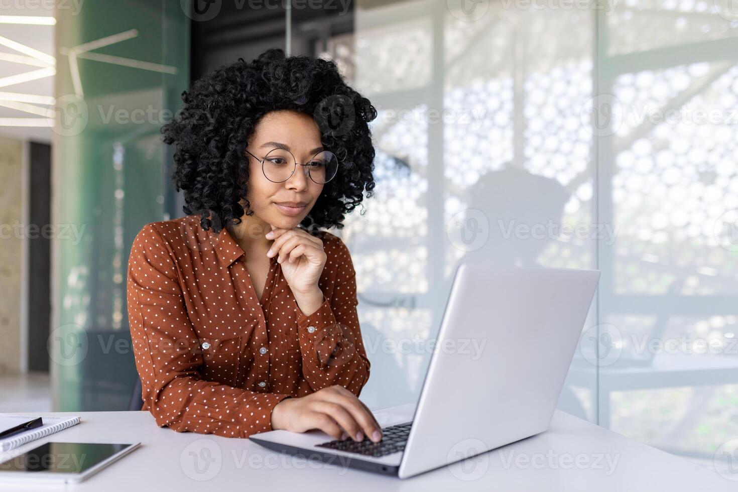 echt denken vrouw werken met laptop, typen Aan toetsenbord, denken geconcentreerd over oplossen stroom problemen, bedrijf vrouw geslaagd tevreden en zelfverzekerd Bij werkplaats binnen kantoor. foto