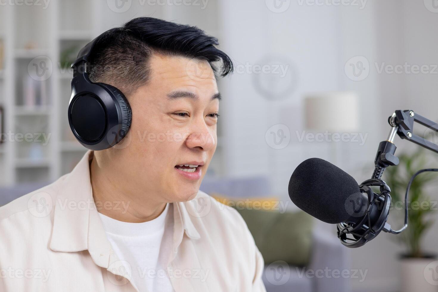 Aziatisch mannetje podcaster sprekend in een microfoon terwijl opname inhoud voor zijn podcast in een knus huis studio instelling. foto