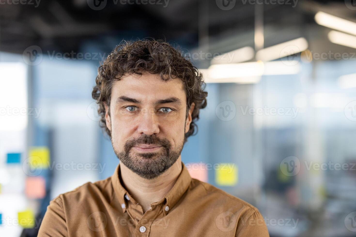 een professioneel Mens staand vol vertrouwen in een goed verlicht, modern kantoor, overbrengen concepten van bedrijf, succes, en zakelijke levensstijl. foto