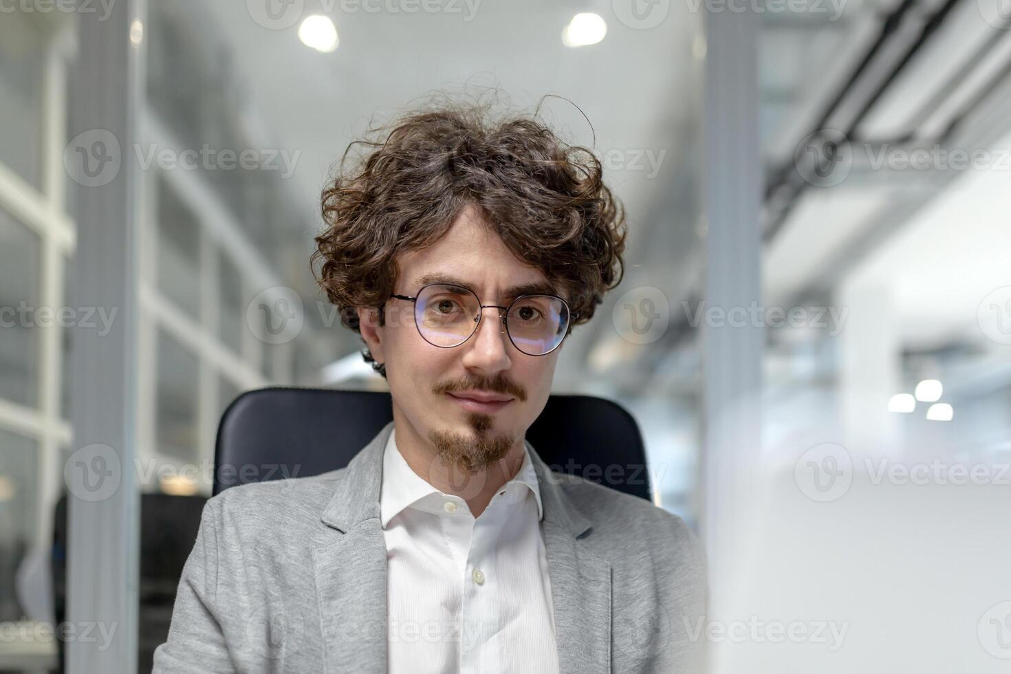 professioneel jong mannetje uitvoerend werken aandachtig Bij zijn bureau in een goed verlicht kantoor ruimte, uitstralend vertrouwen en concentratie in zijn zakelijke rol. foto