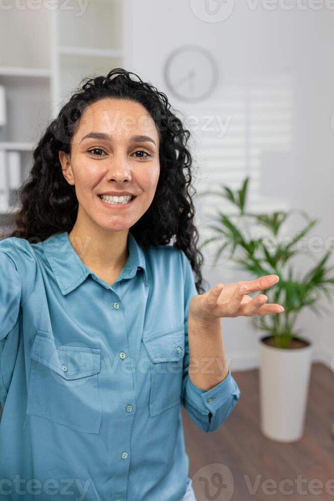 zelfverzekerd professioneel in een blauw overhemd gebaren met een Open hand- gedurende een bedrijf presentatie in een modern kantoor instelling. foto