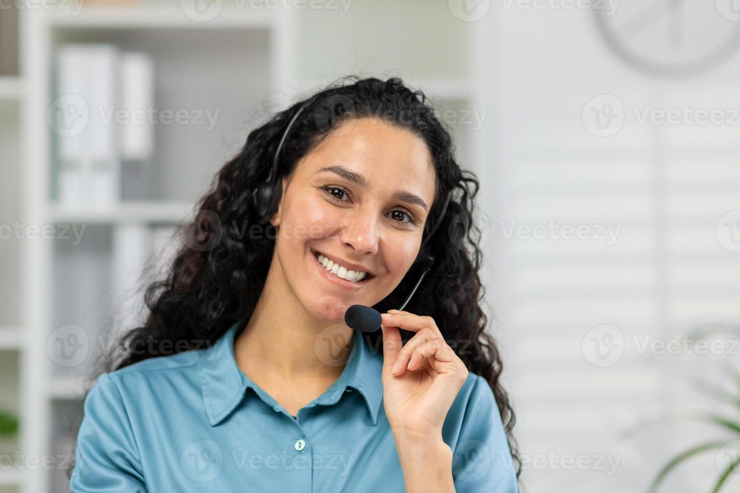 een vrolijk vrouw met een koptelefoon innemend in een vriendelijk telefoongesprek, op zoek direct Bij de camera, mogelijk het verstrekken van klant ondersteuning of virtueel bijstand van een kantoor. foto