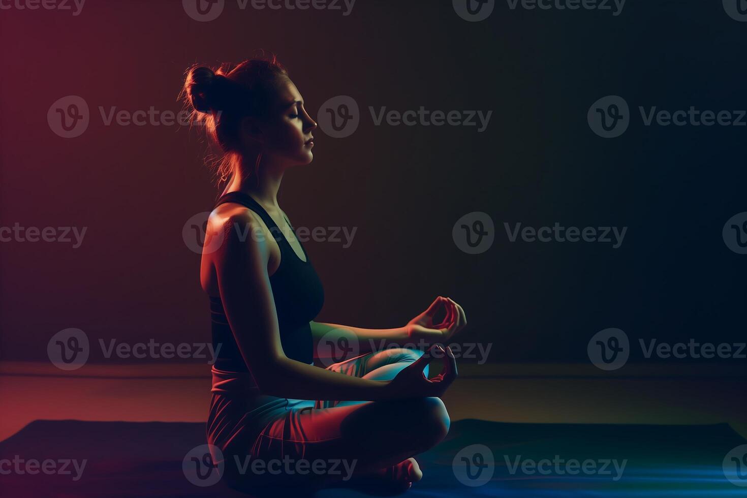 jong vrouw in sportkleding is mediteren in lotus positie in donker kamer foto