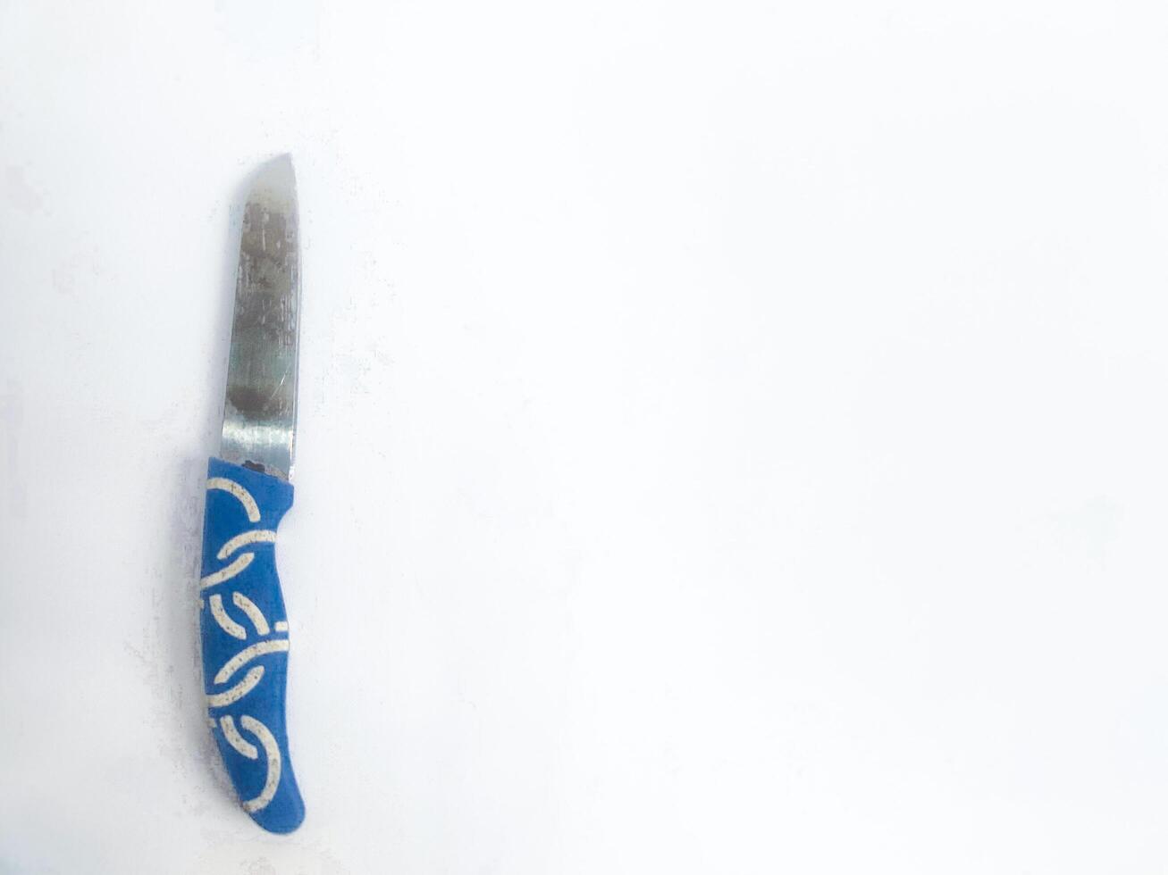 fotografie van een klein blauw snijdend mes Aan een geïsoleerd wit achtergrond foto