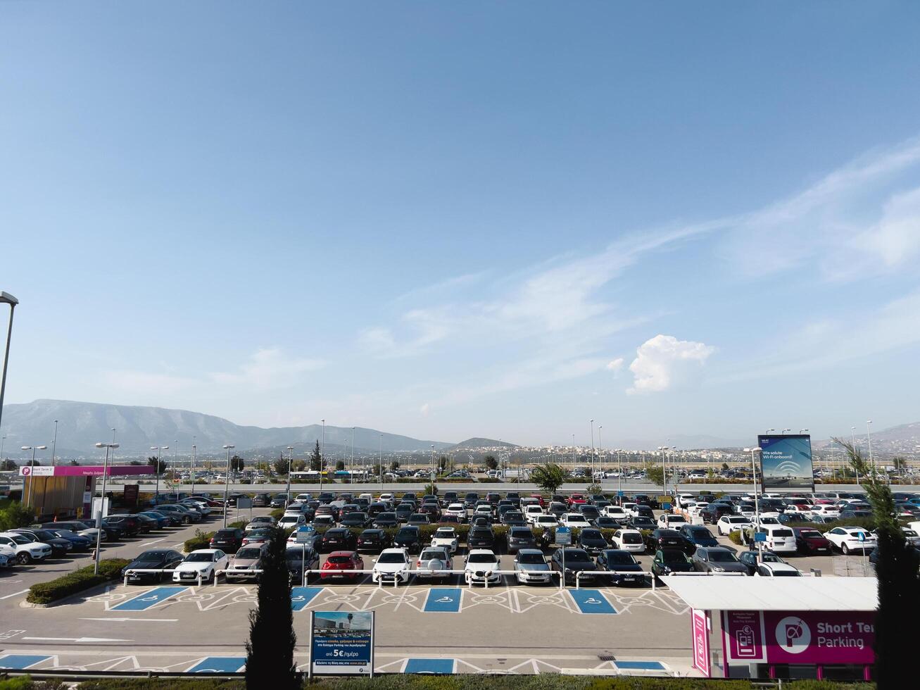 fijn, Griekenland - 20 augustus 2023. reusachtig parkeren veel met geparkeerd auto's tegen de backdrop van een berg reeks foto